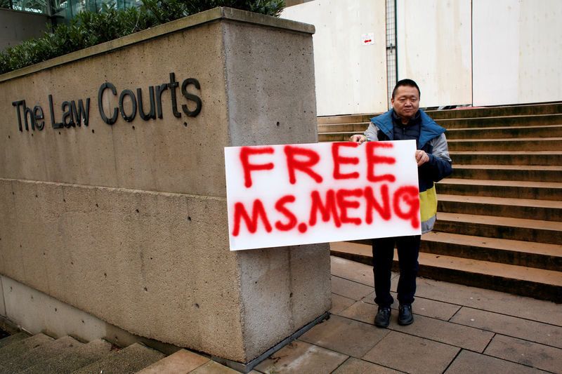 © Reuters. FILE PHOTO: A man holds a sign outside of the B.C. Supreme Court bail hearing of Huawei CFO Meng Wanzhou, who is being held on an extradition warrant in Vancouver