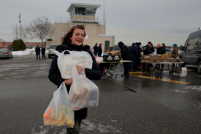 © Reuters. FILE PHOTO: Buller helps her mother pick up pick up supplies being distributed by Gather food pantry at the U.S. Coast Guard Portsmouth Harbor base in New Castle