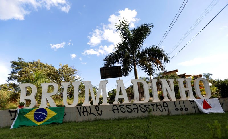 © Reuters. A graffiti at the entrance of the city of Brumadinho reading "Vale murderer" is seen between the national Brazilian flag and Minas Gerais state flag after a dam owned by Brazilian mining company Vale SA collapsed, in Brumadinho