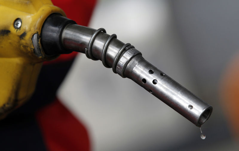 © Reuters. An employee holds a gas pump to refill a car at a petrol station in central Seoul