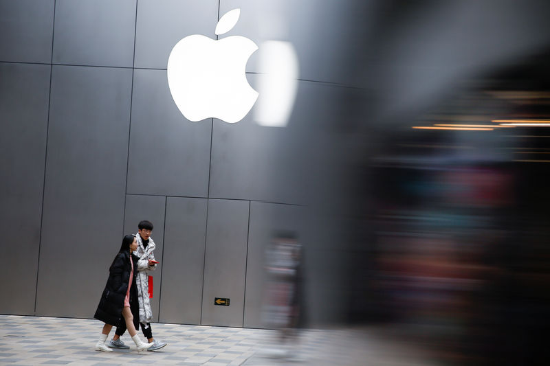 © Reuters. Прохожие у официального магазина Apple в Пекине