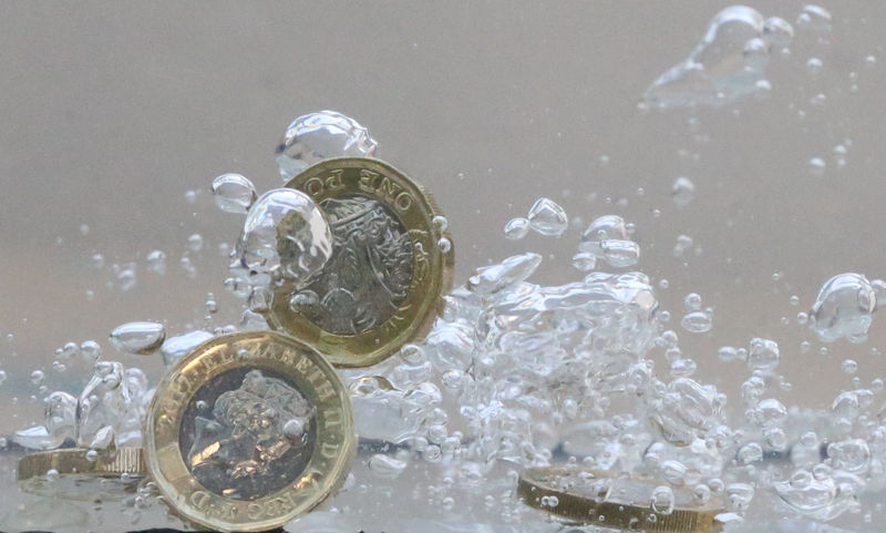 © Reuters. UK pound coins plunge into water in this illustration picture