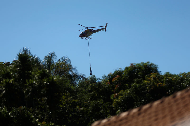 © Reuters. A body recovered after a tailings dam owned by Brazilian mining company Vale SA collapsed, is suspended from a helicopter, in Brumadinho