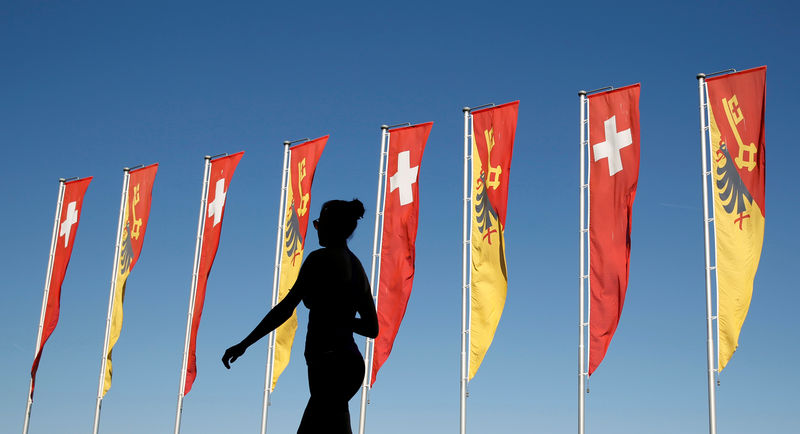 © Reuters. FILE PHOTO: A woman walks past flags along Lake Geneva in Switzerland