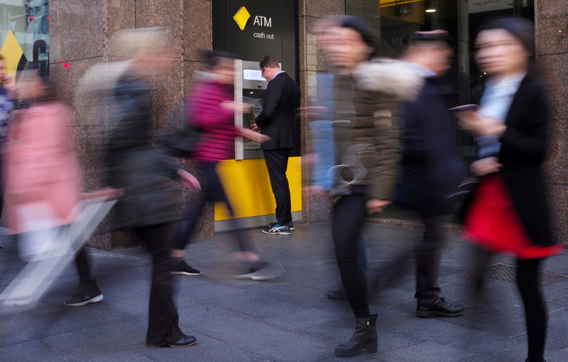 © Reuters. FILE PHOTO: A man banks at a Commonwealth Bank automatic teller machine in Sydney, Australia