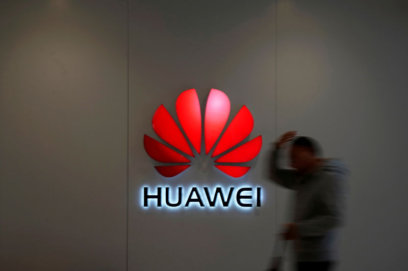 © Reuters. FILE PHOTO: Man walks by a Huawei logo at a shopping mall in Shanghai