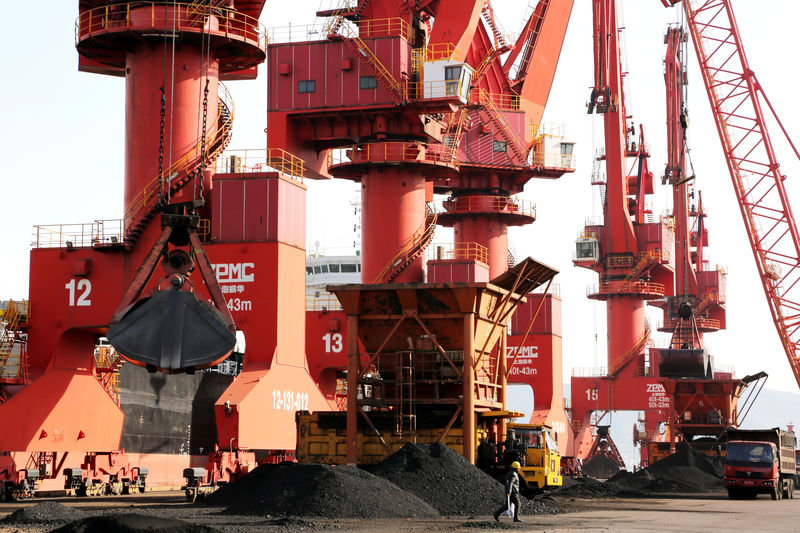 © Reuters. Cranes unload coal from a cargo ship at a port in Lianyungang