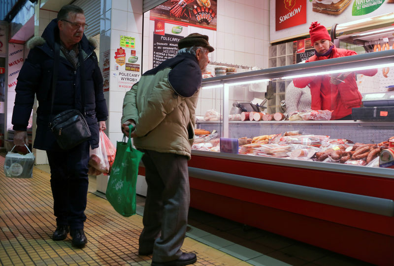 © Reuters. A man looks at meat products at a market in Gdynia