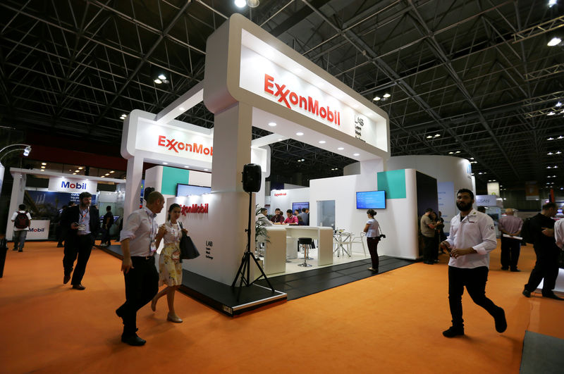 © Reuters. FILE PHOTO: People walk near the booth of the Exxon Mobil Corp at the Rio Oil and Gas Expo and Conference in Rio de Janeiro