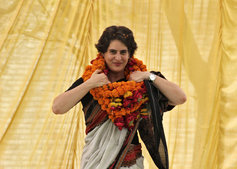 © Reuters. Priyanka Gandhi Vadra adjusts her flower garlands during an election meeting at Rae Bareli