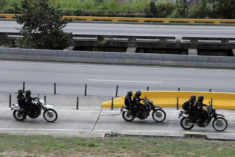 © Reuters. IMAGEN DE ARCHIVO. Miembros de la FAES conducen por una calle de Caracas durante un operativo.