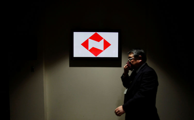 © Reuters. FILE PHOTO : A man walks past a logo of Nippon Life at the company's headquarters in Tokyo