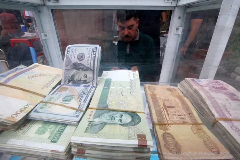 © Reuters. A man counts Iranian rials at a currency exchange shop, before the start of the U.S. sanctions on Tehran, in Basra