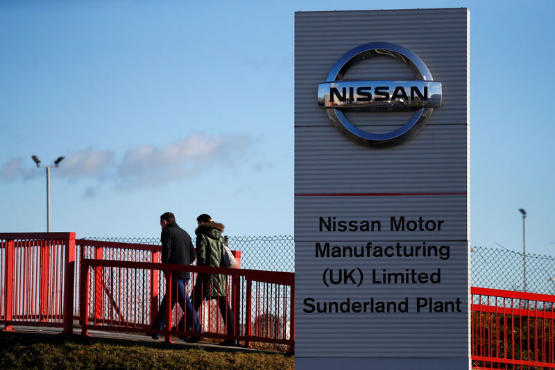 © Reuters. People walk past a sign at the Nissan car plant in Sunderland