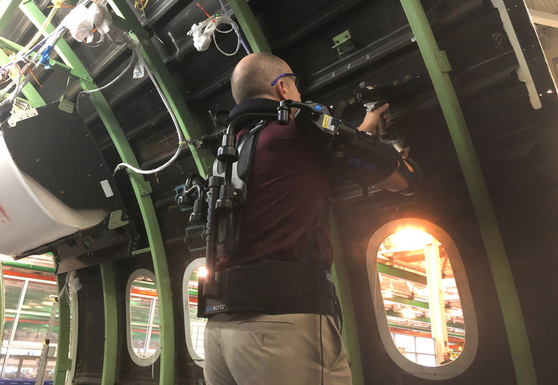 © Reuters. FILE PHOTO: Employee Rob Gross gets a boost from a gas-powered exoskeleton Boeing is using to boost productivity and safety at their production factory in North Charleston