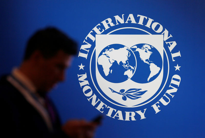 © Reuters. A participant stands near a logo of IMF at the International Monetary Fund - World Bank Annual Meeting 2018 in Nusa Dua