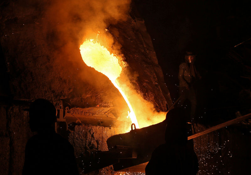 © Reuters. FILE PHOTO: A worker observes an electric furnace inside a steel factory on the outskirts of Jammu