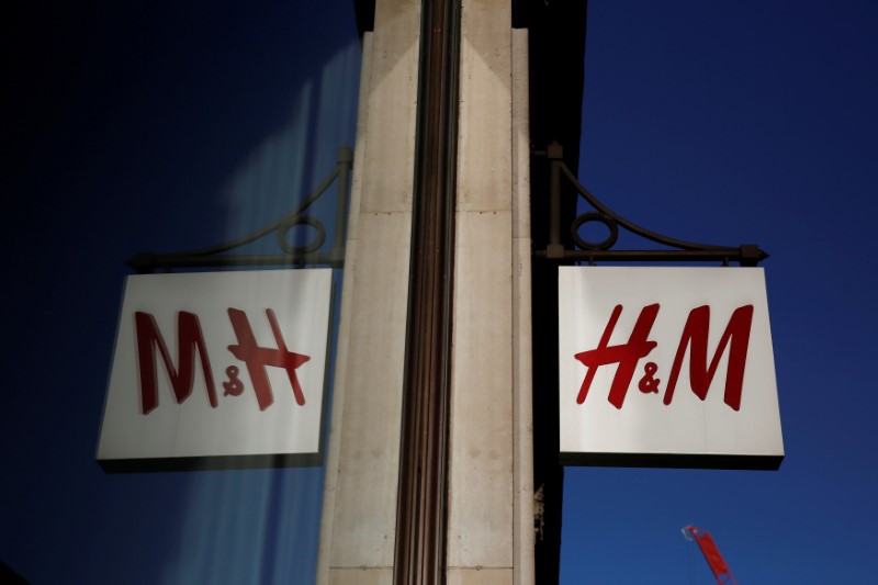 © Reuters. FILE PHOTO: A logo is reflected in the window as it hangs outside the H&M store on Oxford Street in London