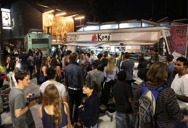 © Reuters. FILE PHOTO: People stand in line to order from food trucks during monthly first Friday event on Abbot Kinney Boulevard in Venice, California