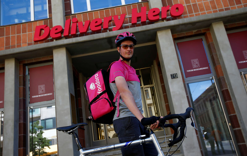 © Reuters. A Foodora delivery cyclist poses in front of Delivery Hero headquarters in Berlin