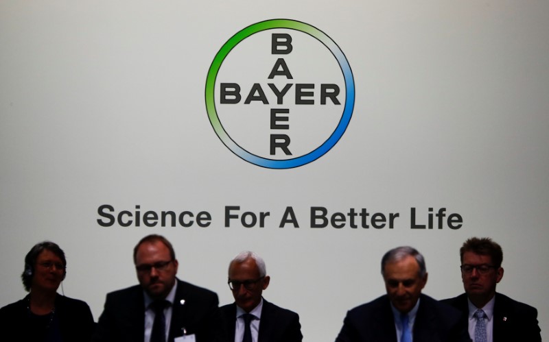© Reuters. FILE PHOTO: Members of the supervisory board of German pharmaceutical and chemical maker Bayer AG are silhouetted against the company's logo at the annual general shareholders meeting in Bonn