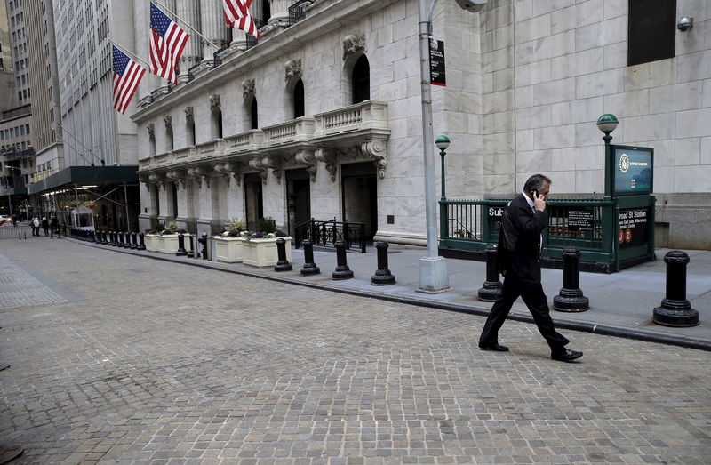 © Reuters. FILE PHOTO - Trader walks outside New York Stock Exchange (NYSE) before opening bell of trading session in New York