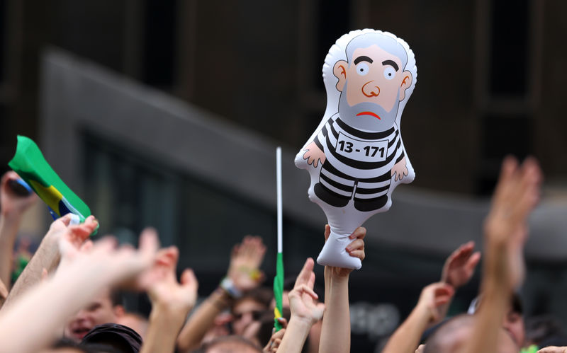 © Reuters. Un manifestante sostiene un muñeco conocido como 'Pixuleco' y que representa al expresidente Inácio Lula da Silva, durante una protesta en Sao Paulo.