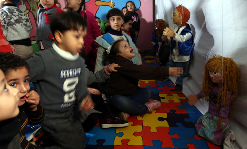 © Reuters. دمى تحركها خيوط ترسم الابتسامة على وجوه الأطفال بغزة