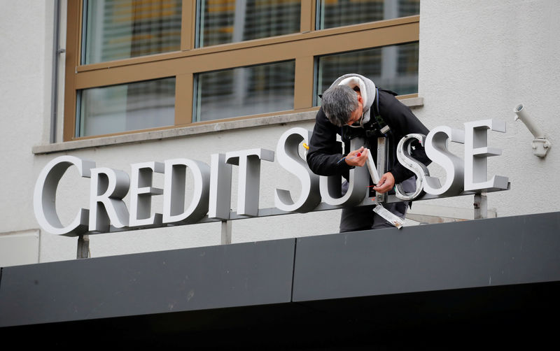 © Reuters. FILE PHOTO: A worker repairs a Credit Suisse sign in Zurich