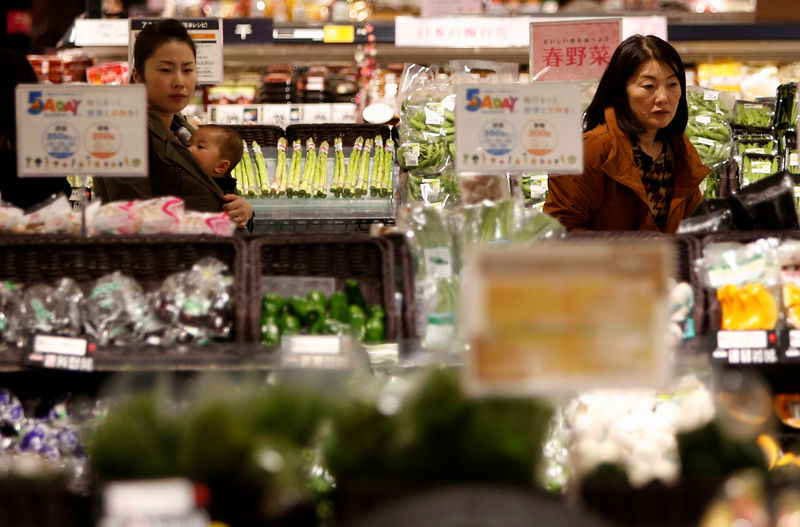 © Reuters. FILE PHOTO - Shoppers browse vegetables at a supermarket in Chiba