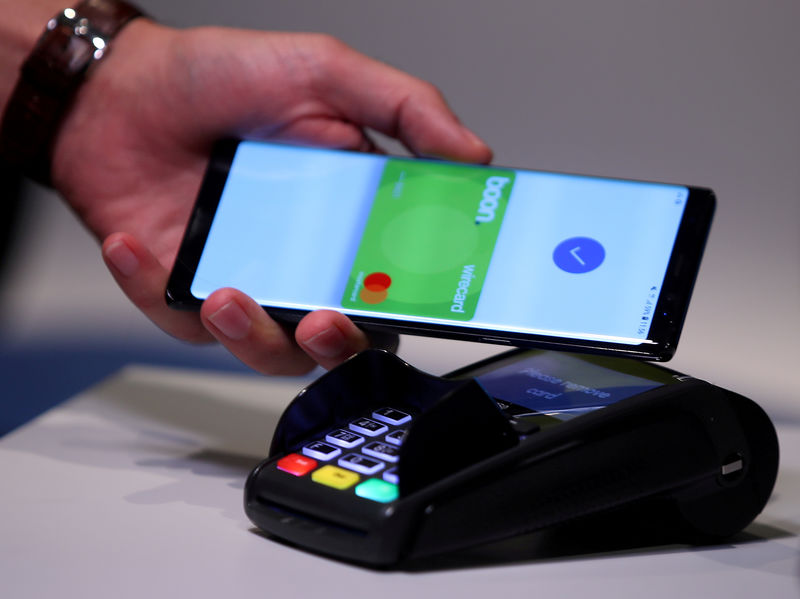 © Reuters. FILE PHOTO: An employee of Wirecard AG, presents the contactless payment system "boon" at the company's headquarters in Aschheim