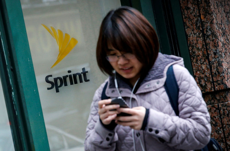© Reuters. FILE PHOTO - A woman walks past a Sprint store in New York