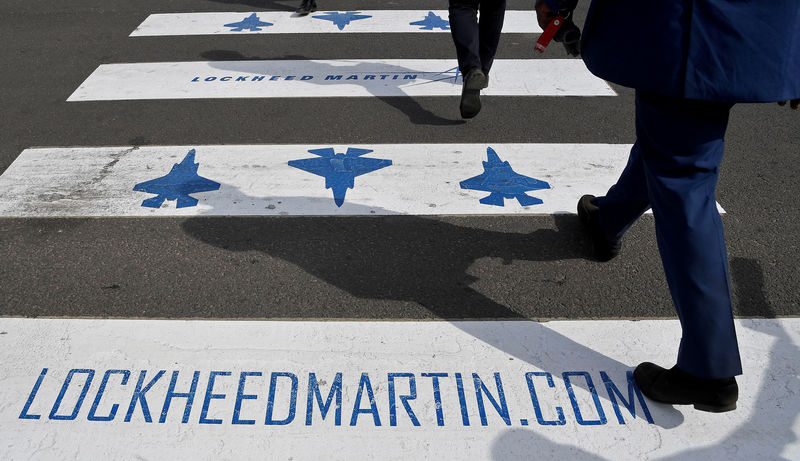 © Reuters. FILE PHOTO - Trade visitors are seen walking over a road crossing covered with Lockheed Martin branding at Farnborough International Airshow in Farnborough, Britain