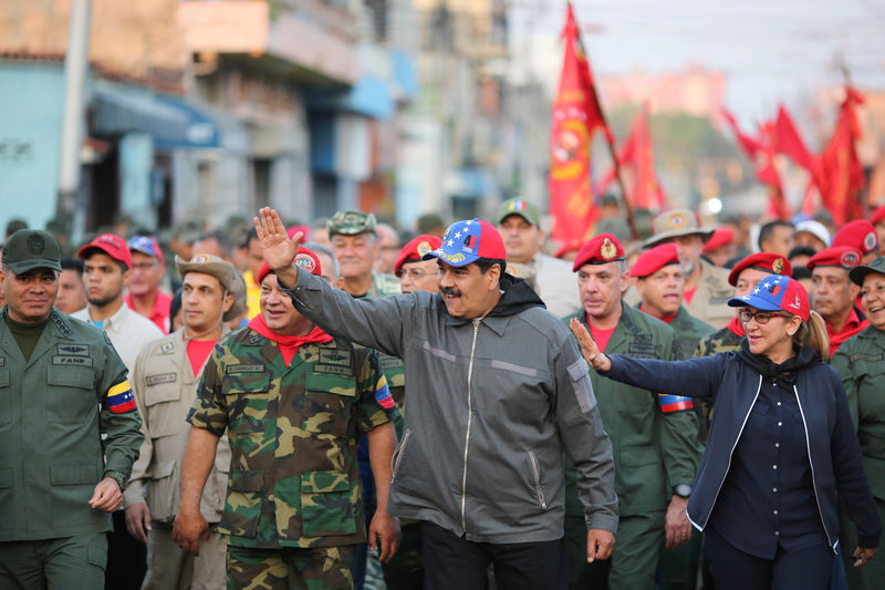 © Reuters. Imagen de archivo del presidente de Venezuela, Nicolás Maduro, y su esposa, Cilia Flores, mientras andan junto a soldados en una ceremonia en Maracay, Venezuela.