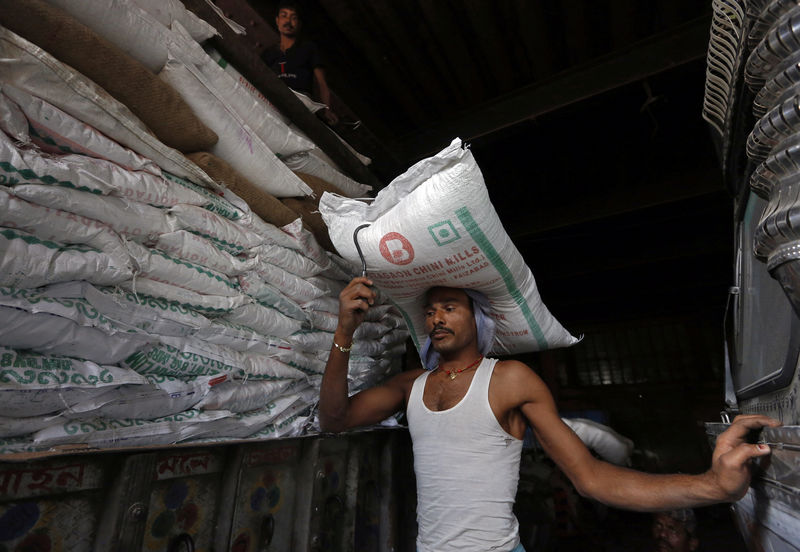 © Reuters. A labourer carries a sack of sugar to load it onto a supply truck at a market area in Kolkata