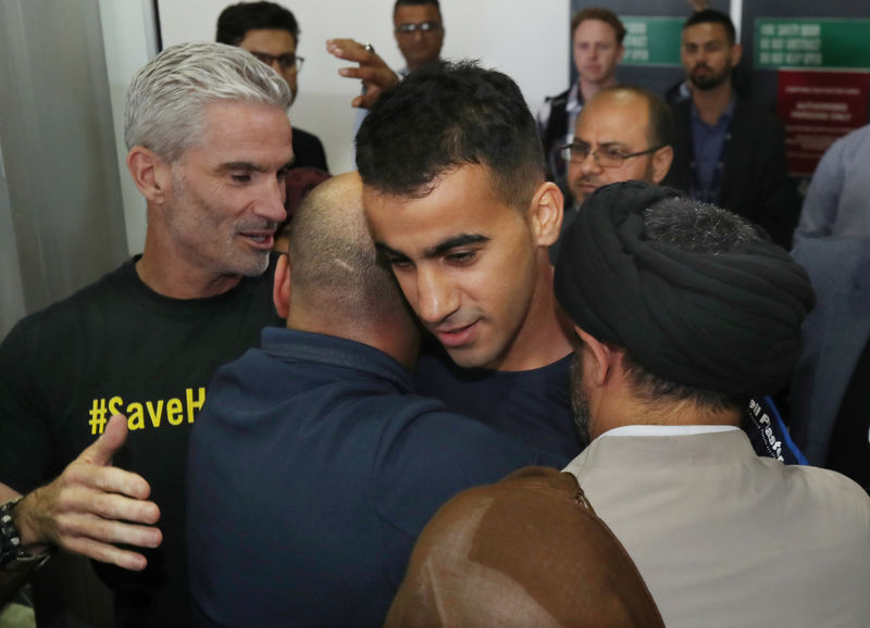 © Reuters. Former Socceroo Craig Foster (left) is seen as refugee footballer Hakeem Al-Araibi (centre) arrives at Melbourne International Airport in Melbourne