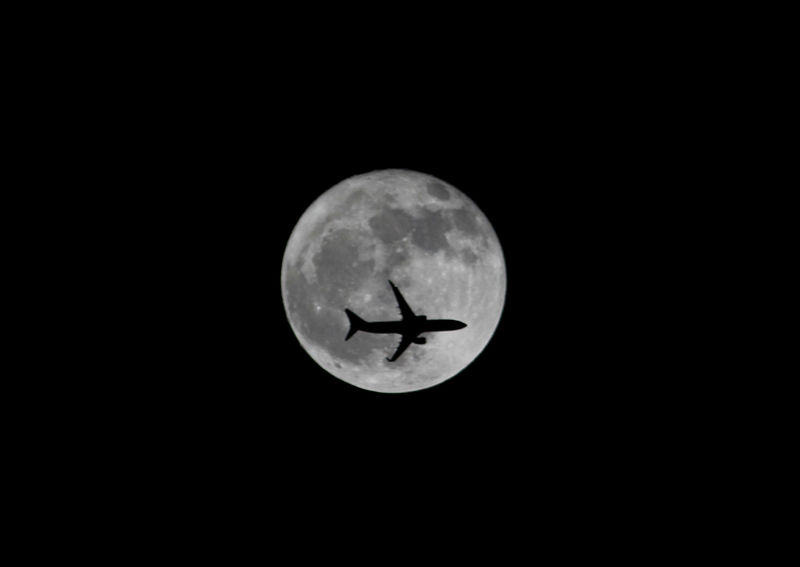 © Reuters. Passenger plane passes the moon as it comes into land at the international airport in Chennai