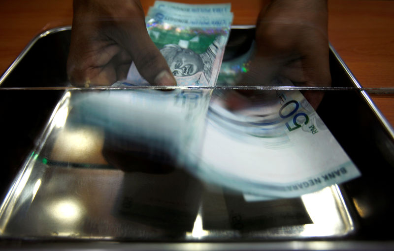 © Reuters. Money changer counts ringgit at shop in Putrajaya