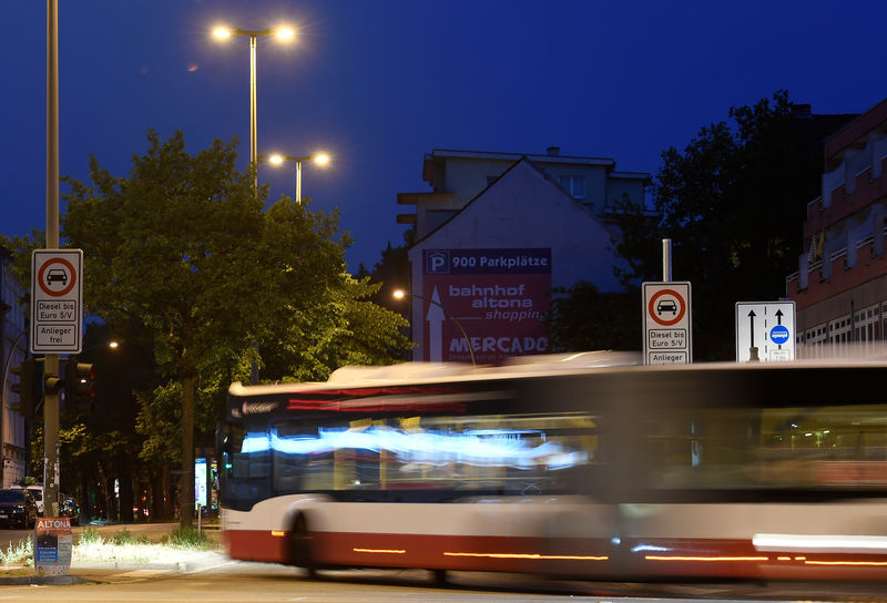 © Reuters. A bus passes traffic signs, which ban diesel cars at the Max-Brauer Allee in downtown Hamburg