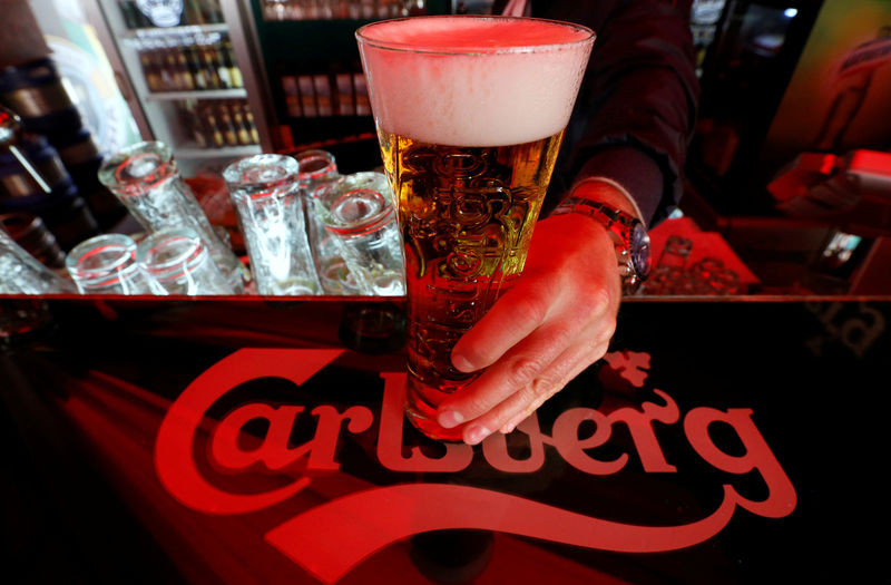 © Reuters. FILE PHOTO: A bartender holds a glass of Carlsberg beer in a bar in St. Petersburg