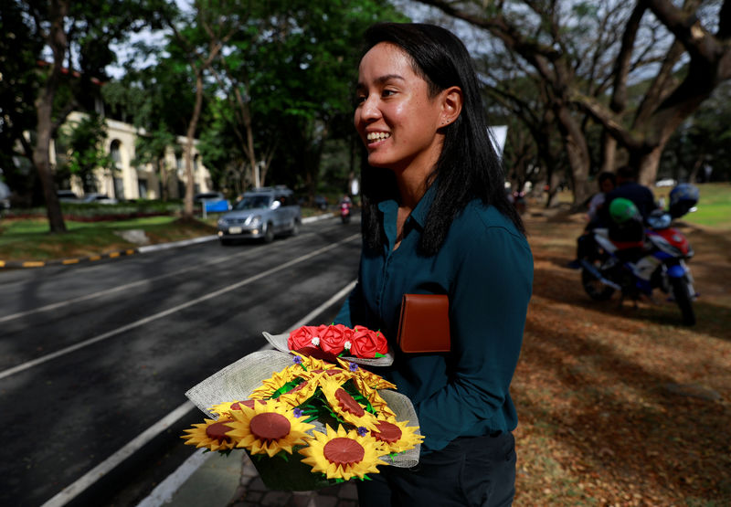 © Reuters. في عيد الحب.. فلبينيون يعبرون عن حبهم الأبدي بباقات زهور ورقية