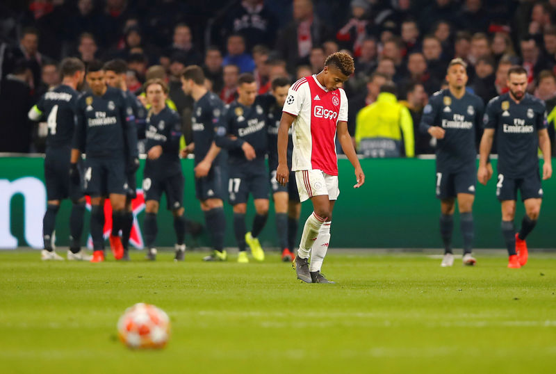 © Reuters. Los jugadores del Real Madrid celebran tras el gol anotado por Marcos Asensio mientras el futbolista del Ajax David Neres mira el piso, en el partido que ganó el equipo español por 2-1 en la ida de octavos de final de la Liga de Campeones, en Ámsterdam