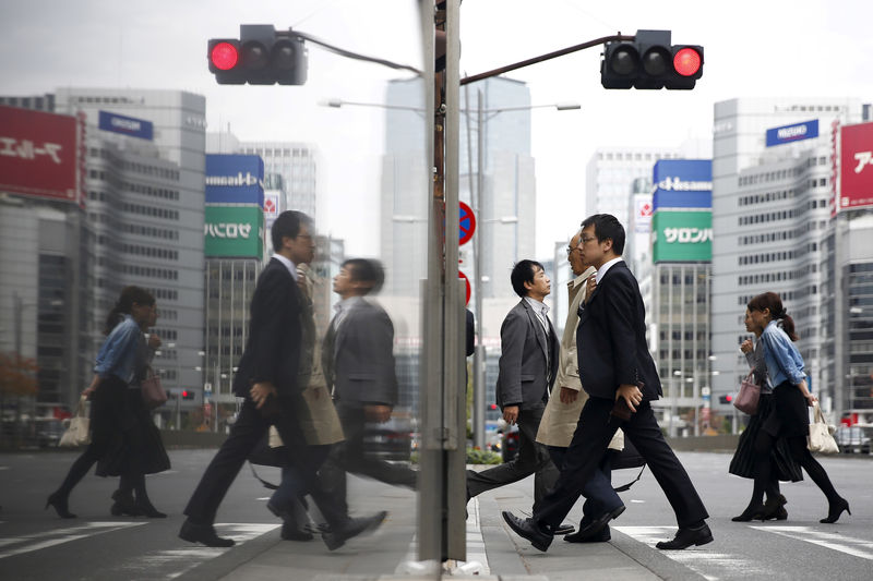 © Reuters. FILE PHOTO - People cross a street in a business district in central Tokyo