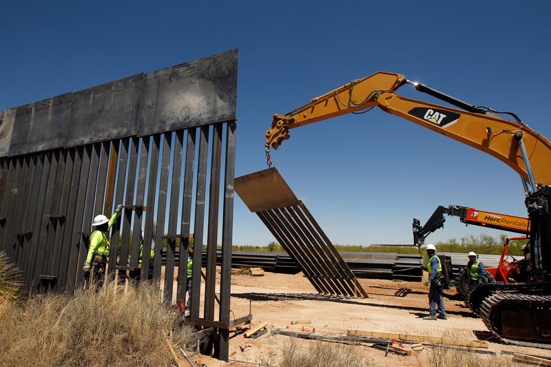 © Reuters. Construction workers are seen next to heavy machinery while working on new bollard wall in Santa Teresa as seen from the Mexican side of the border in San Jeronimo