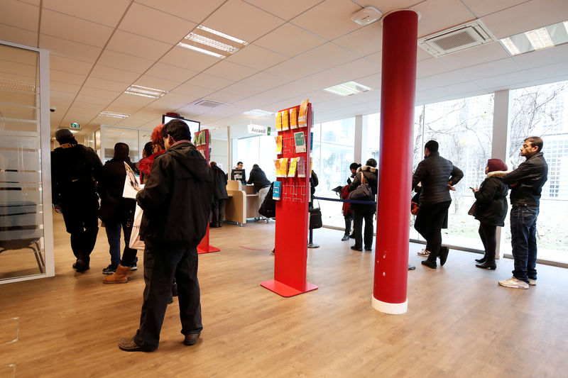 © Reuters. FILE PHOTO: Job seekers wait to speak with staff at a National Agency for Employment (Pole Emploi) office in Aubervilliers