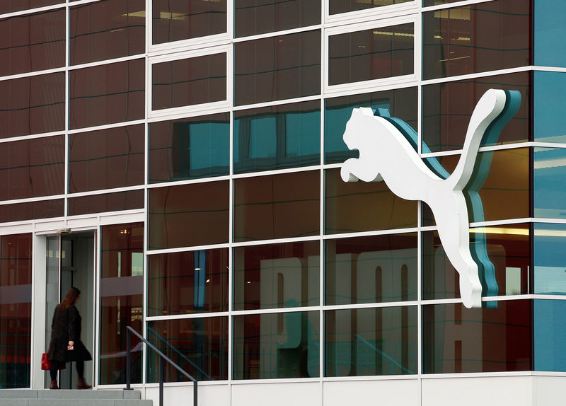 © Reuters. FILE PHOTO - A woman enters the headquarters of German sports goods firm Puma before the company's annual news conference in Herzogenaurach