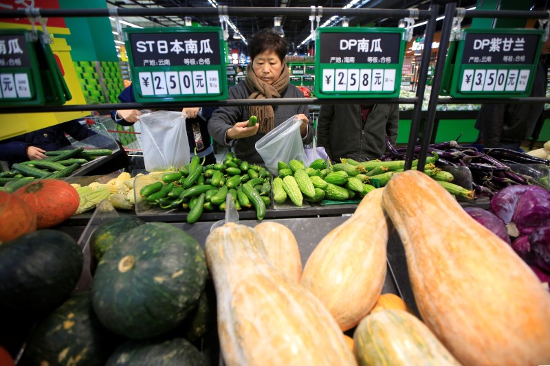 © Reuters. FILE PHOTO: Consumers choose vegetables at a supermarket in Shanghai