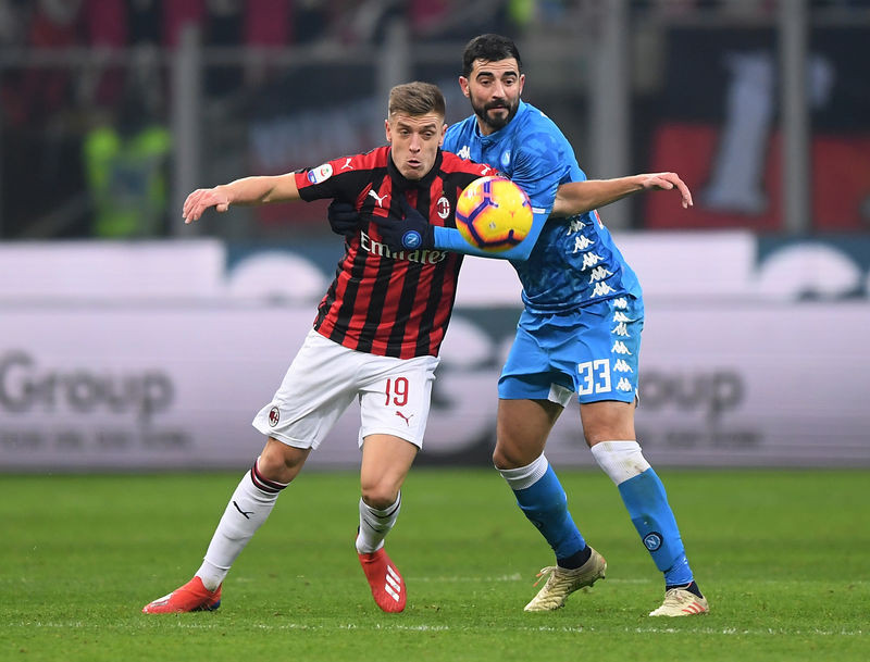 © Reuters. Krzysztof Piatek del AC Milan en acción frente a Raúl Albiol del Napoli