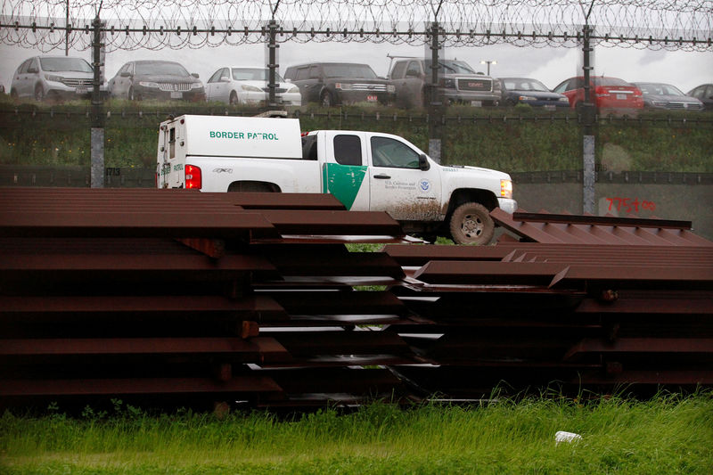 © Reuters. A U.S. border patrol vehicle drives past metal sections to be used to fix the border fence between  Mexico and the U.S., as seen from Tijuana