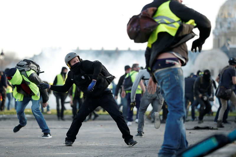 © Reuters. Manifestantes que visten chalecos amarillos se enfrentan a la policía antidisturbios de Francia cerca de Los Invalidos durante una protesta del movimiento en París